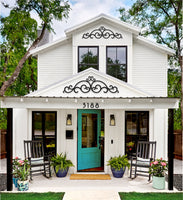 Cute Bungalow with turquoise door and wrought iron accents in gables.